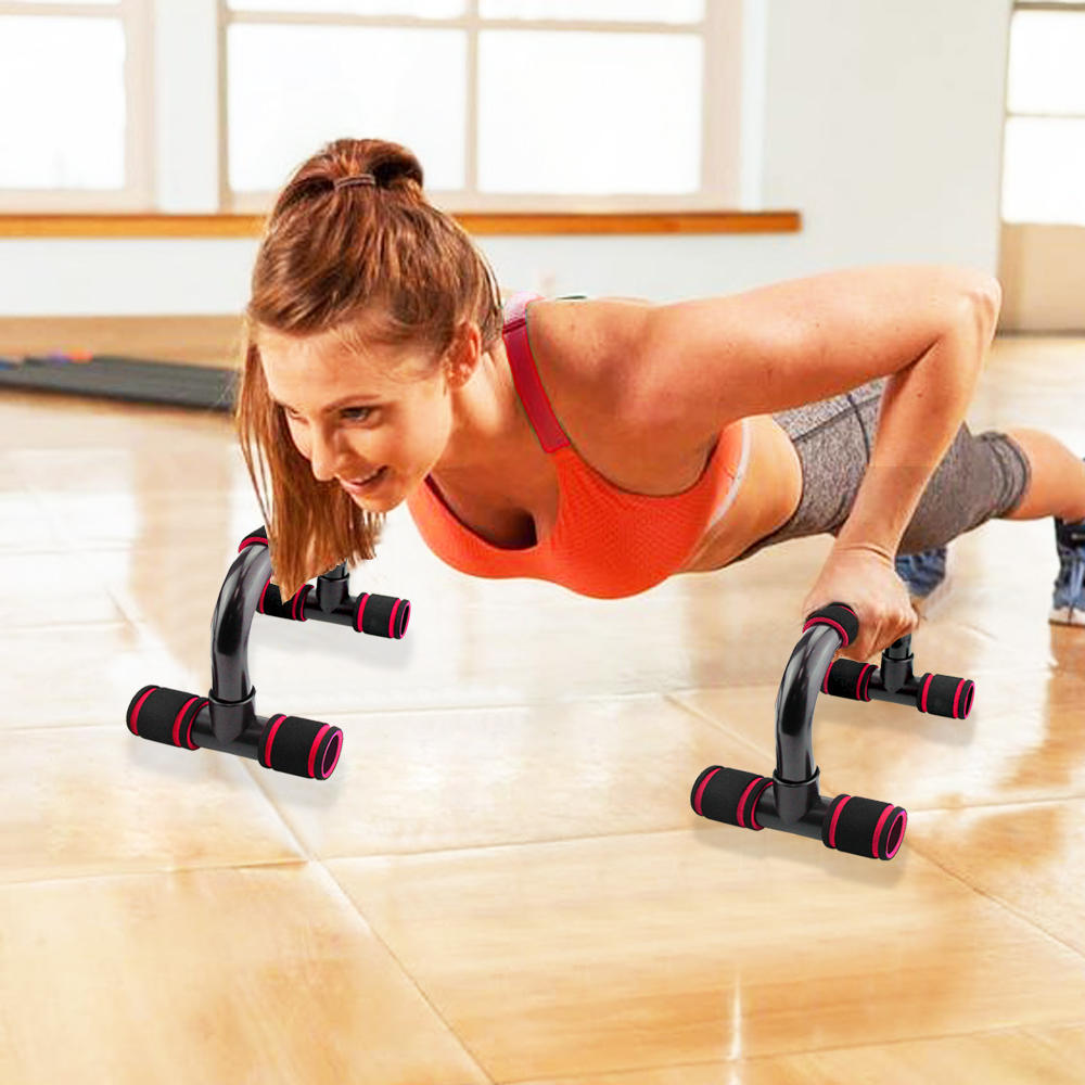 Woman using Fitness Push-up Bar Push-Ups Stands Gym Bars Indoor Fitness with red foam grips during indoor workout for upper body training.