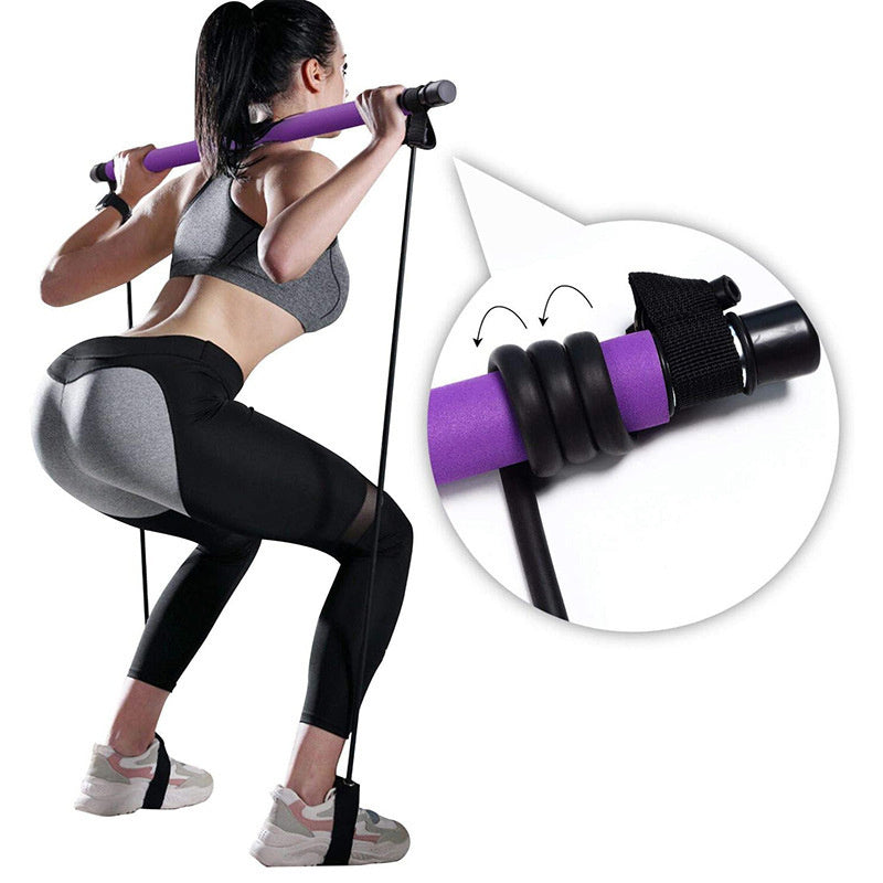 Woman using purple resistance bands for home trainer workout equipment, performing squats with Pilates bar and foot straps.